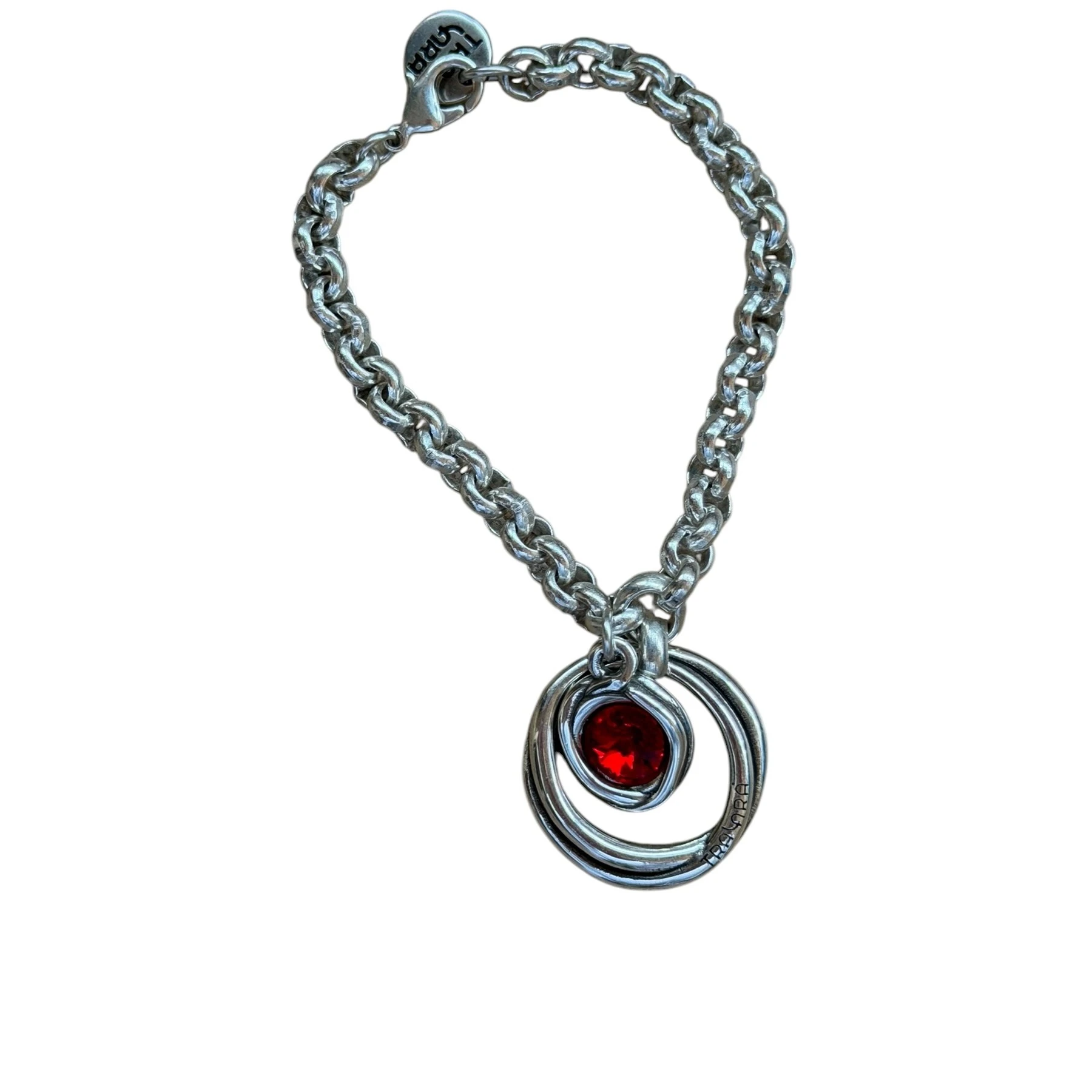 Pulsera de cadena de eslabones plateados con dije circular de diseño en espiral y cristal central rojo.