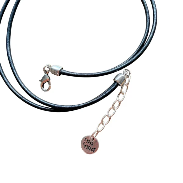 Gargantilla con cordones negros con piedra central en forma de corazón bicolor, mitad calado plateado y mitad resina azul intenso.