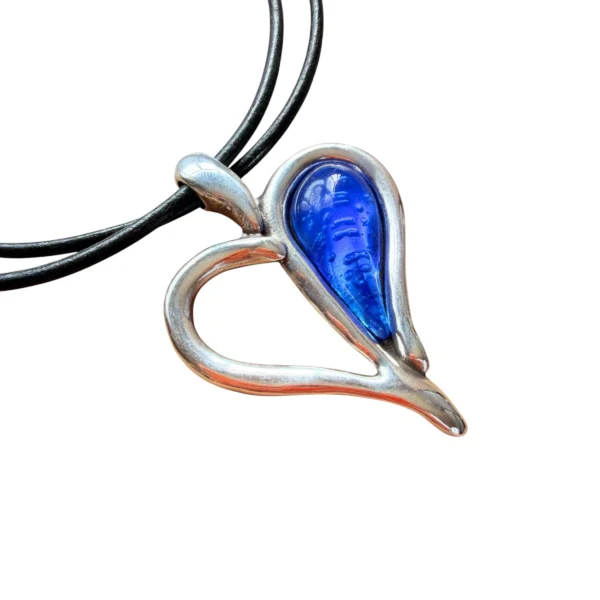 Gargantilla con cordones negros con piedra central en forma de corazón bicolor, mitad calado plateado y mitad resina azul intenso.