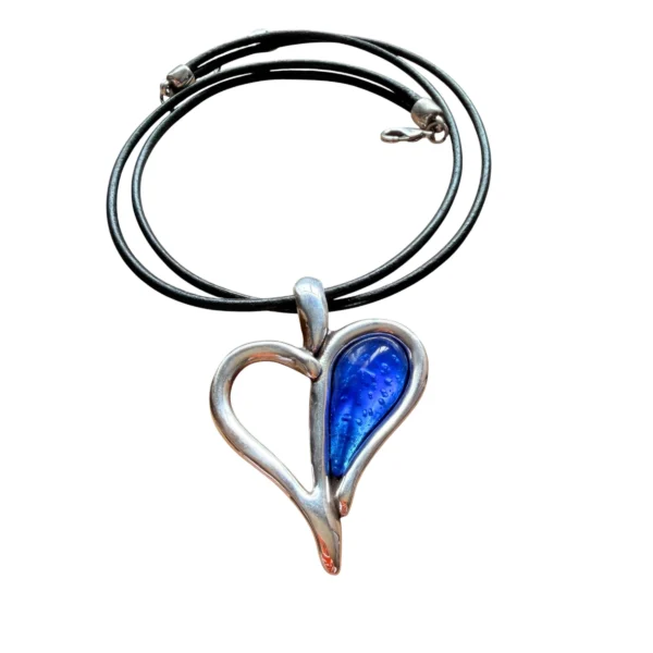 Gargantilla con cordones negros con piedra central en forma de corazón bicolor, mitad calado plateado y mitad resina azul intenso.