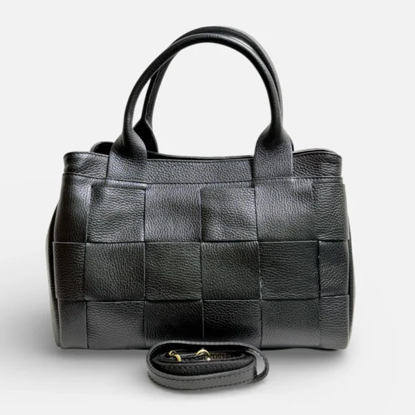 Bolso Tote, artesanal de piel de vacuno color negro con textura entrelazada y doble asa superior. Correa larga extraíble y base reforzada.